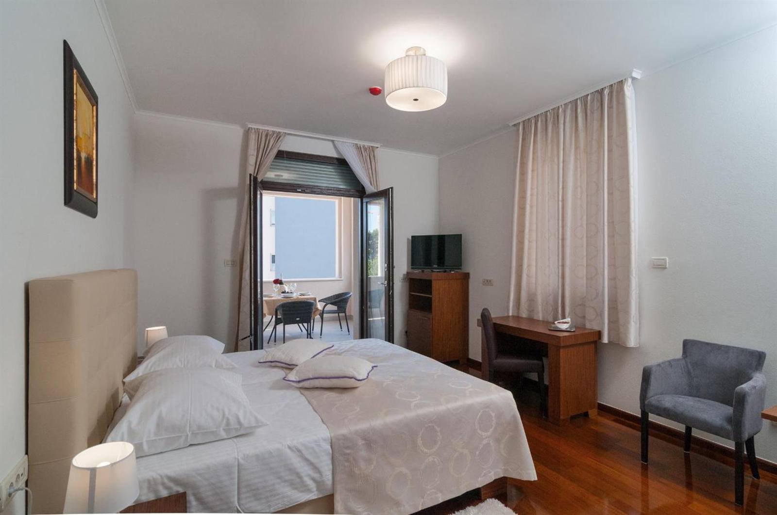 Double room with a wooden floor and a balcony door